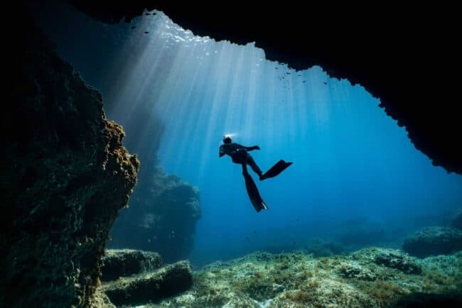 A freediver exits a swim-through