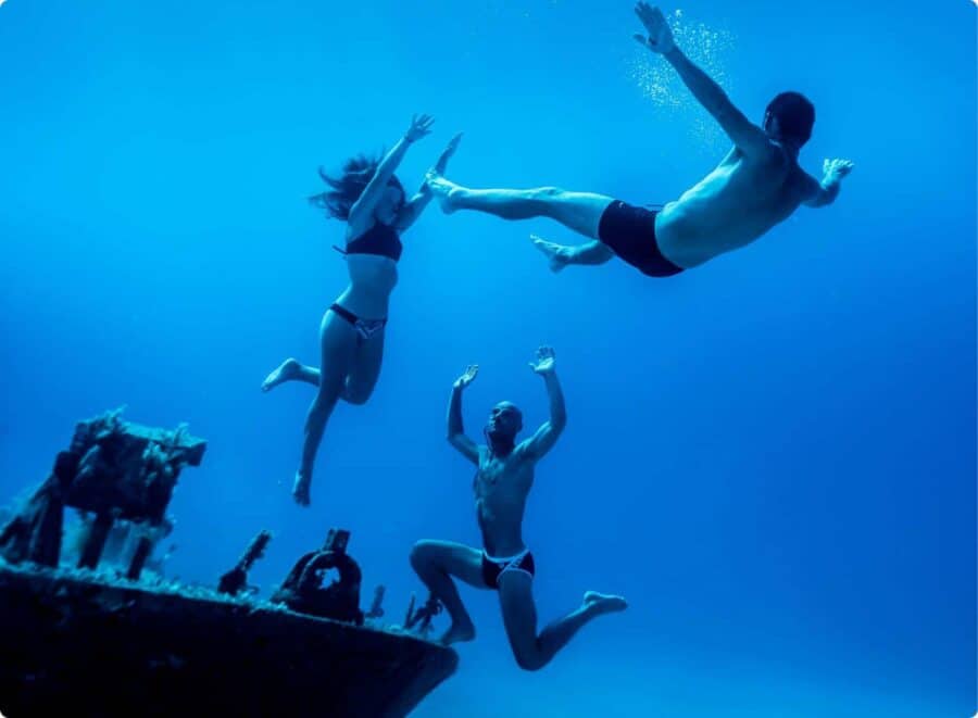 Dramatic scene of Three freedivers on bow of P31 wreck