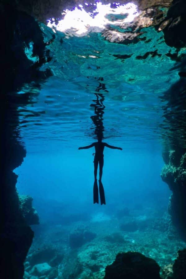 Freediver with arms wide open on surface