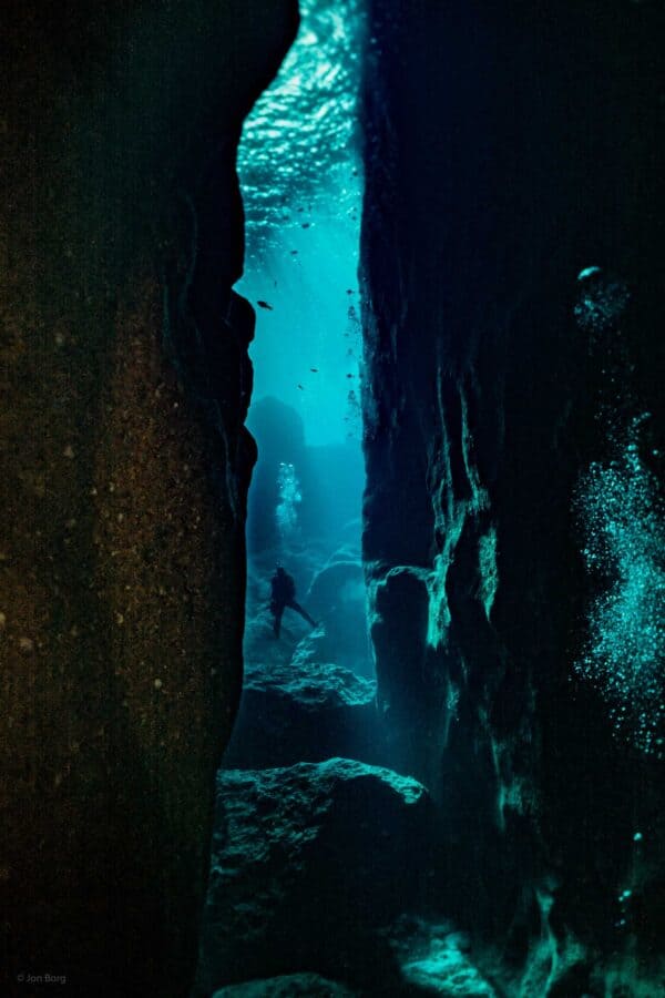 SCUBA diver in between two towering walls of the inland sea