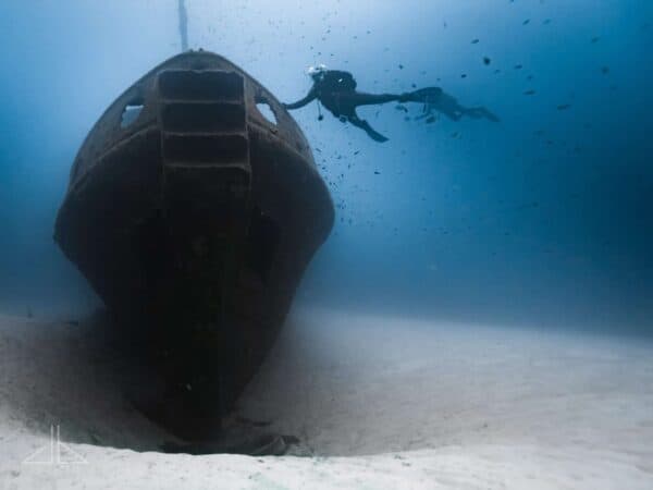 SCUBA diver touch the bow of wreck MV Rozi