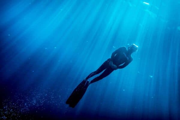 Freediver using positive buoyancy to float to surface