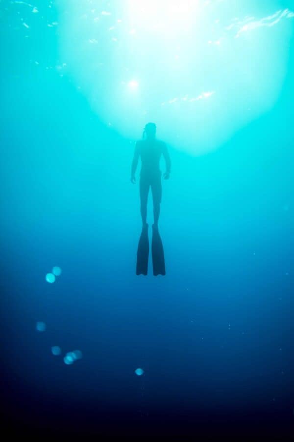 Freediver ascending into light