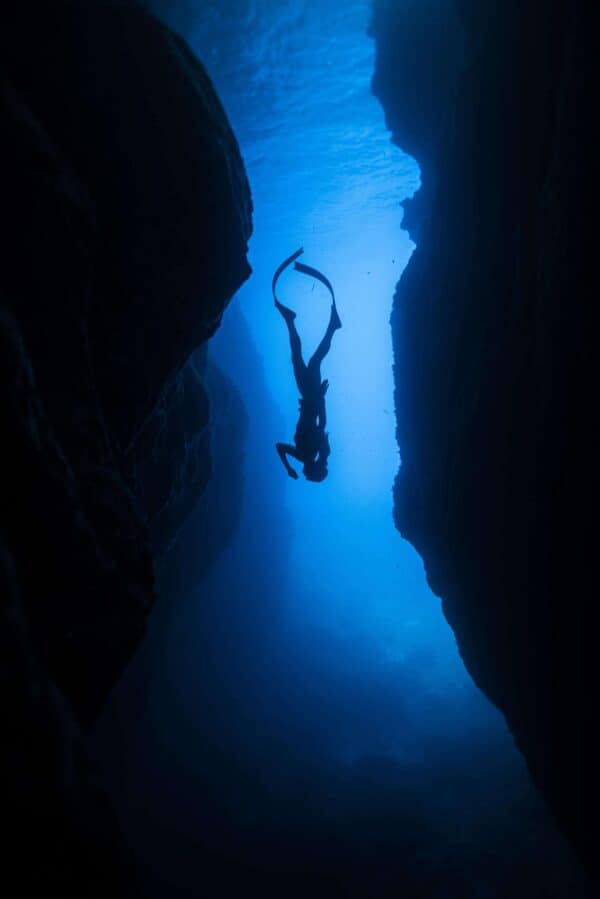 Freediver descending into a cave
