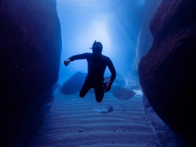 Freediver levitating between two large rocks