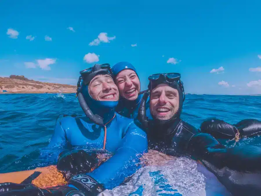 Deep Med's instructors posing with a nice smile by a freediving buoy with blue skies.