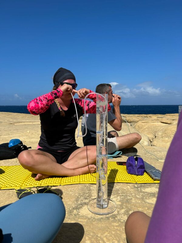 Freediver blows into a tube to practice equalising skills